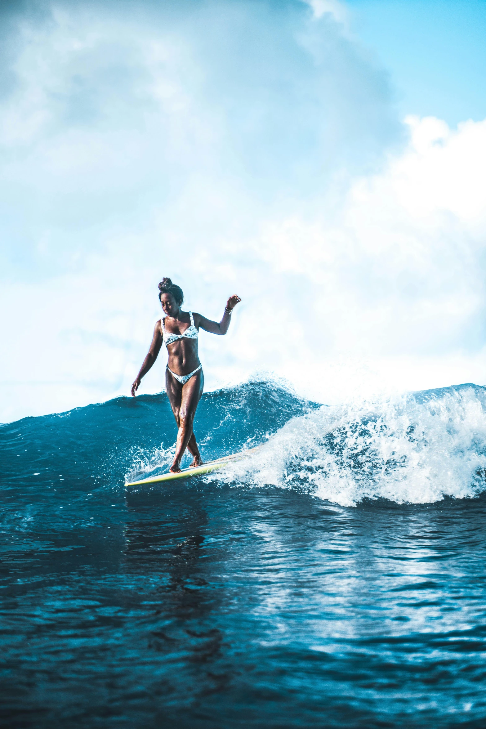 a person in a bikini surfing on the ocean