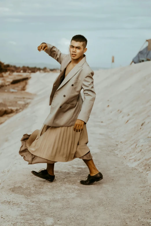 a man in a long skirt is holding his hand out and leaning on a rail