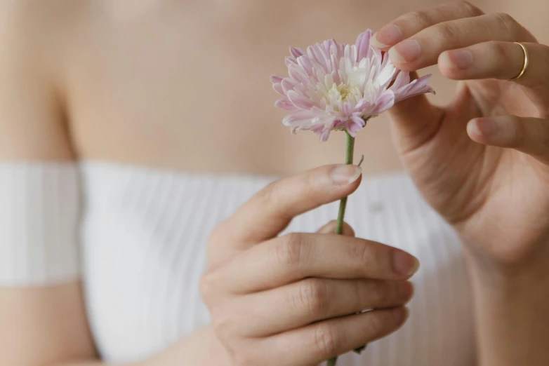 a woman holding a flower in her hands