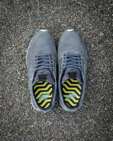 a pair of sneakers that have a yellow and blue stripe on them