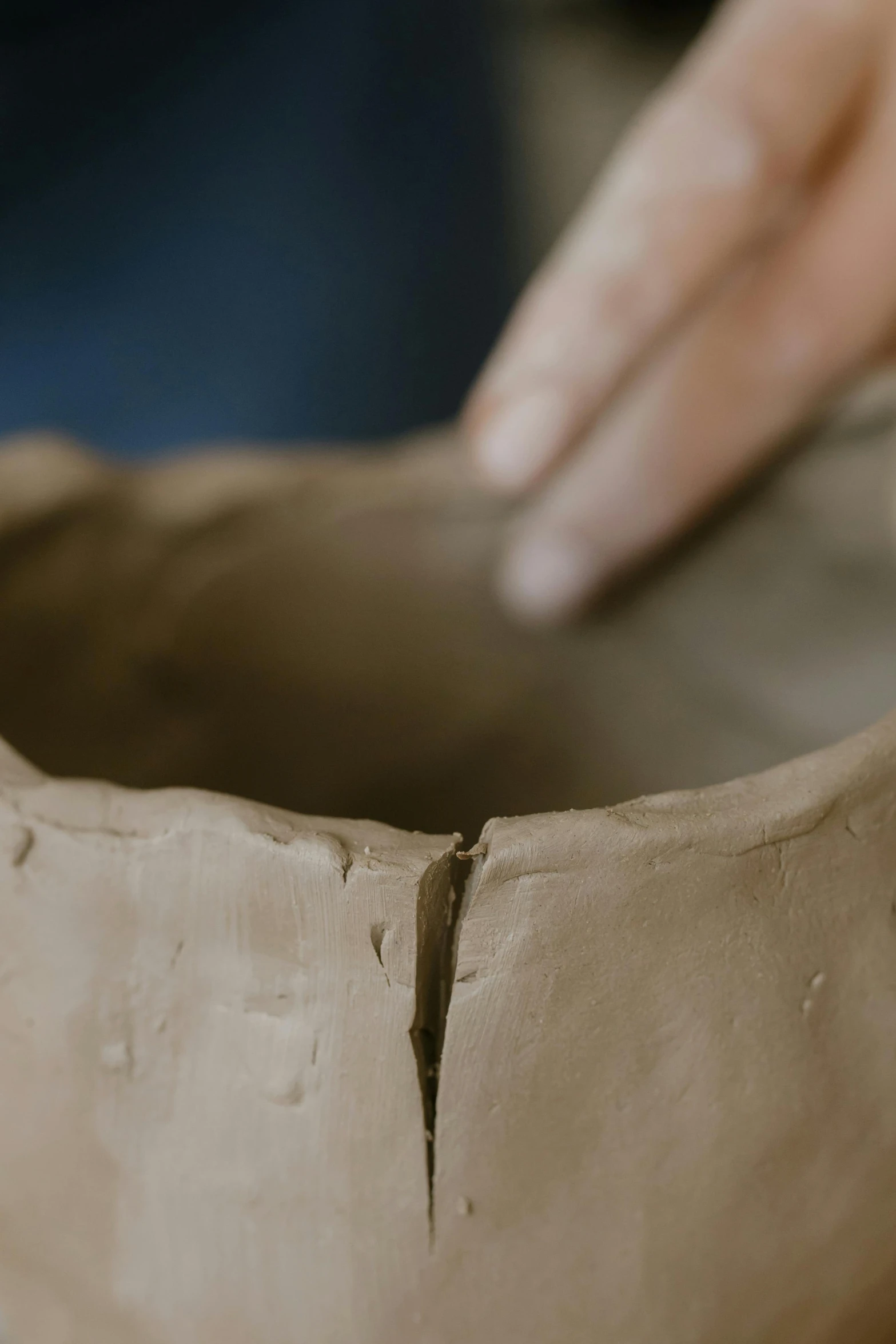 a person holding onto the edge of a pottery pot