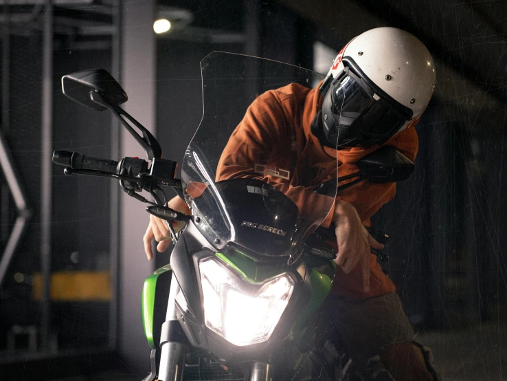 there is a man wearing an orange jacket and helmet sitting on a motorcycle