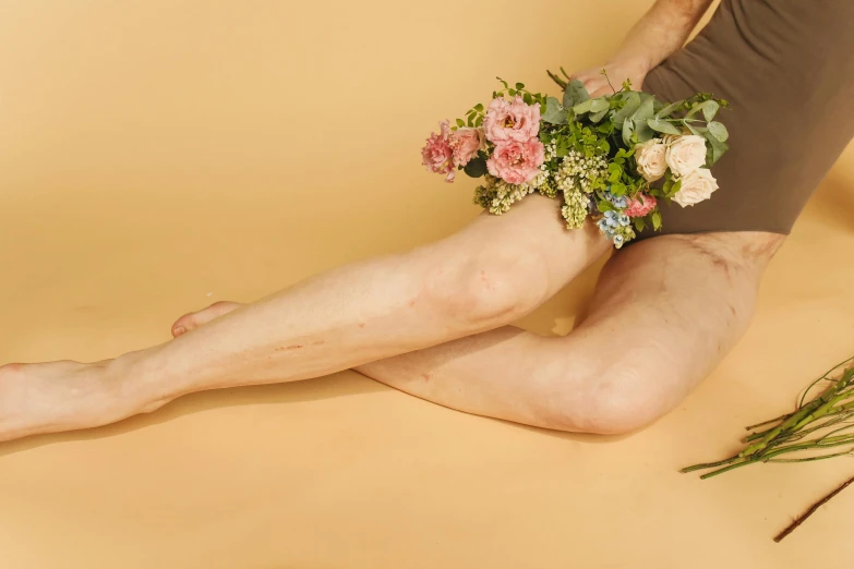 a woman sitting down with a bouquet on her stomach