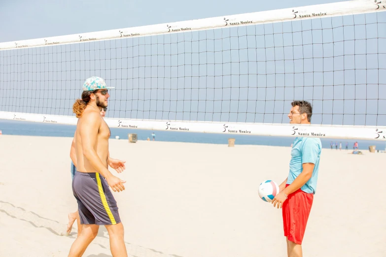 two men on the beach playing volleyball together