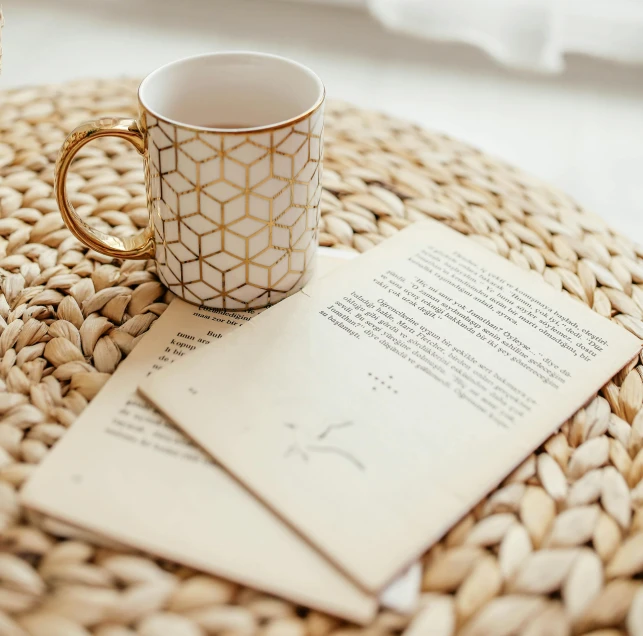 some letters are resting on a table with a coffee cup