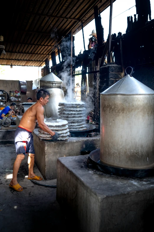 a man that is standing in front of a large pot