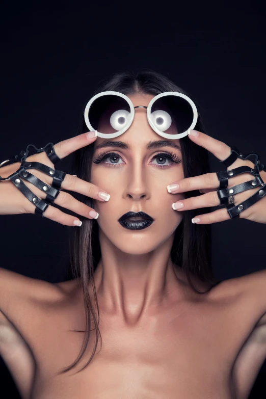 a woman holding two pair of glasses above her face