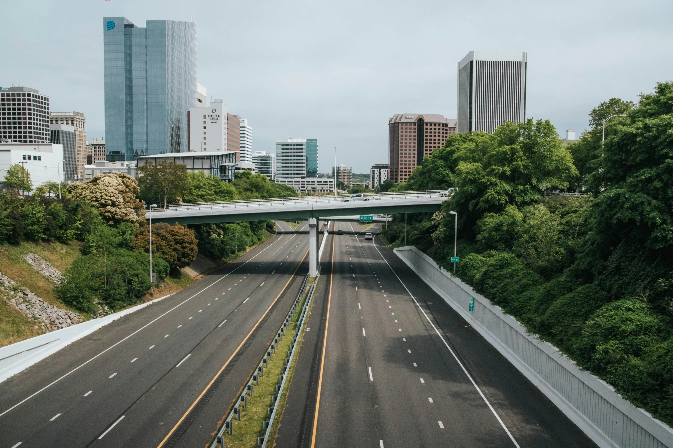 a freeway with two lanes and trees in the background