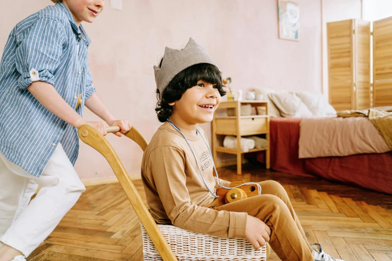 a woman standing and sitting in a chair next to a child