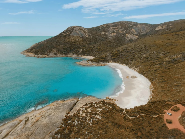 a sandy beach with clear blue waters and a sandy shore