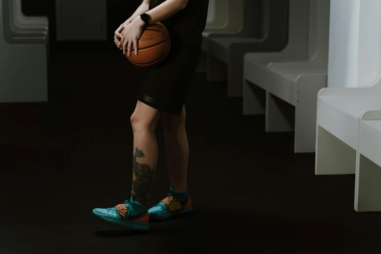 a man wearing blue shoes holding a basketball