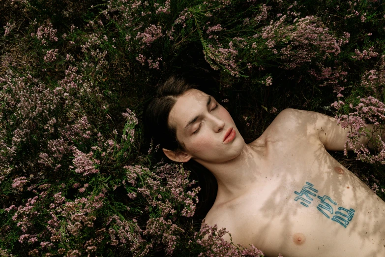 a man has his eyes closed as he lays in the bushes