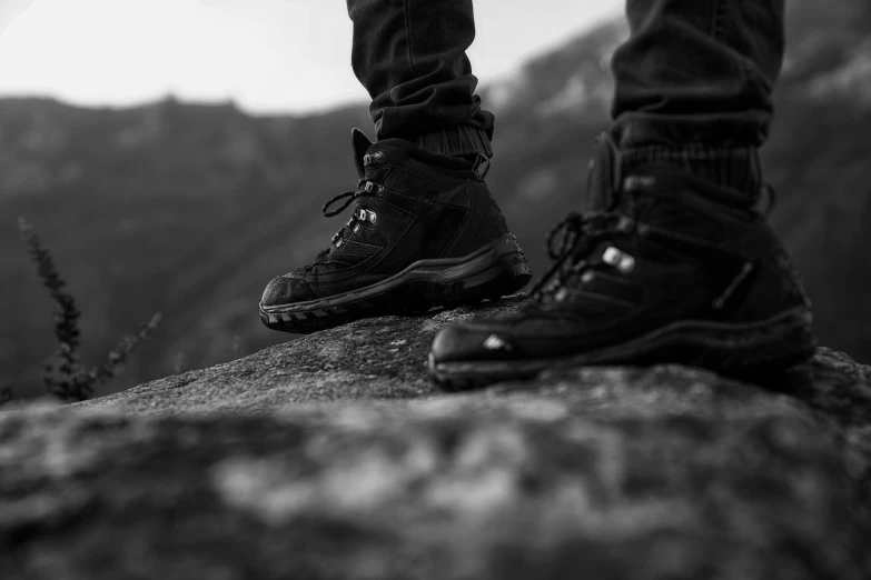 a person standing on a rock on the side of a mountain