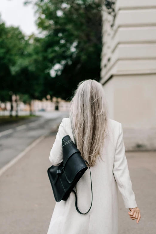 a woman walking down a street with her handbag