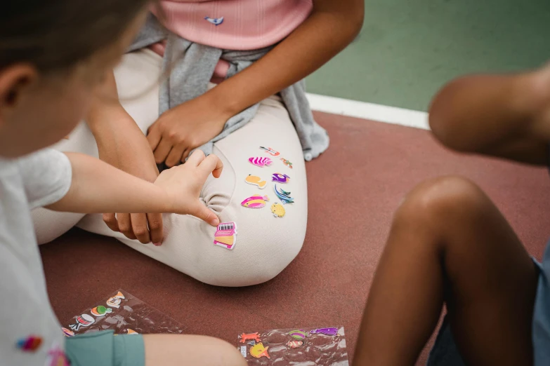 three young children sitting around each other in a circle