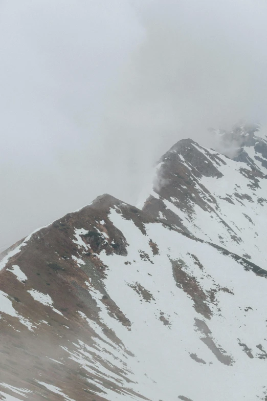 a plane flying over a mountain covered in snow