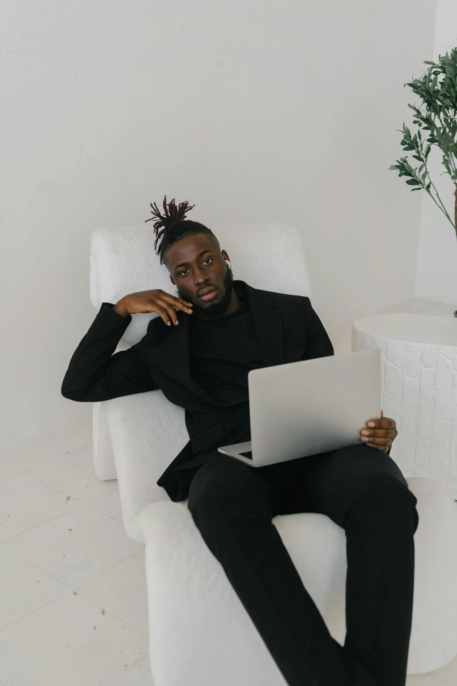 a man sitting in a chair with a laptop