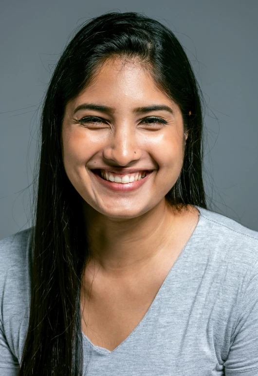 smiling woman in gray shirt and long hair