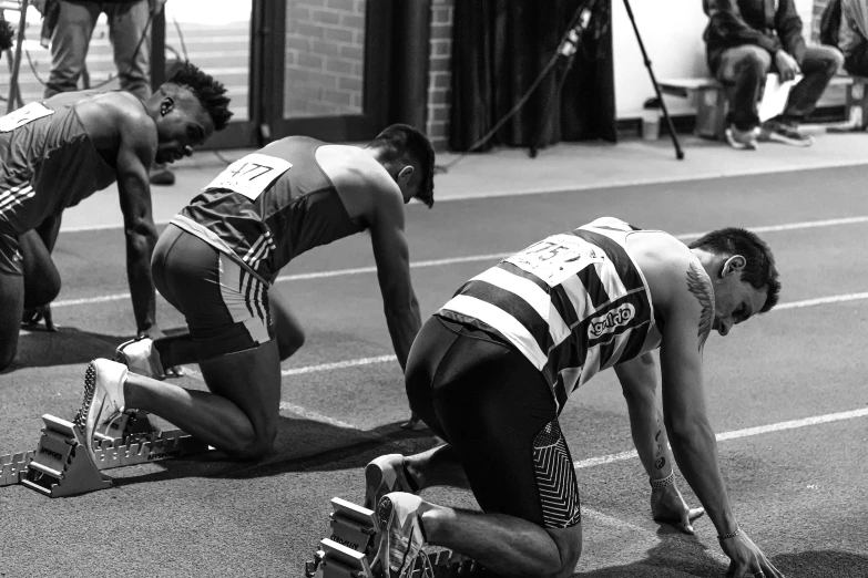 there are three men on the ground tying their shoes