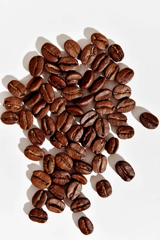 a pile of coffee beans sitting on top of a white table