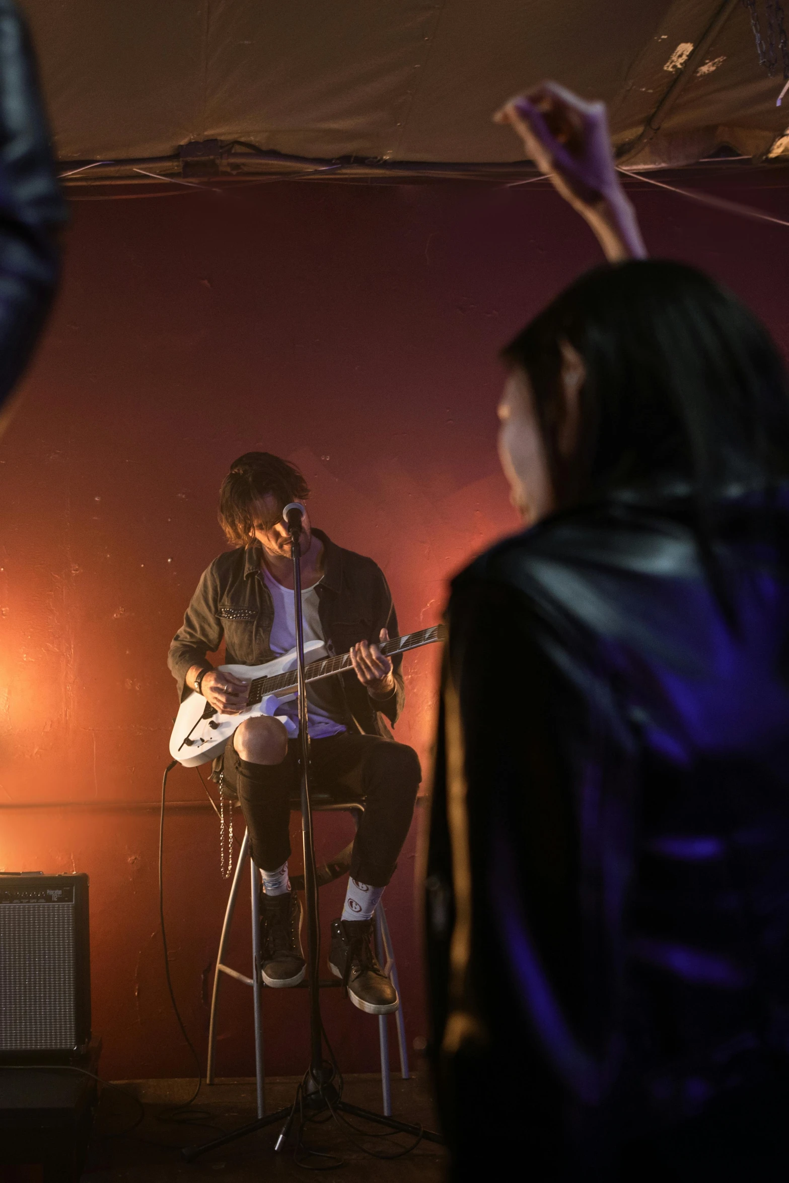 a person on a stool and microphone behind them