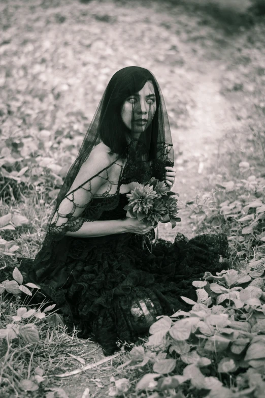 a woman sitting in the woods with flowers