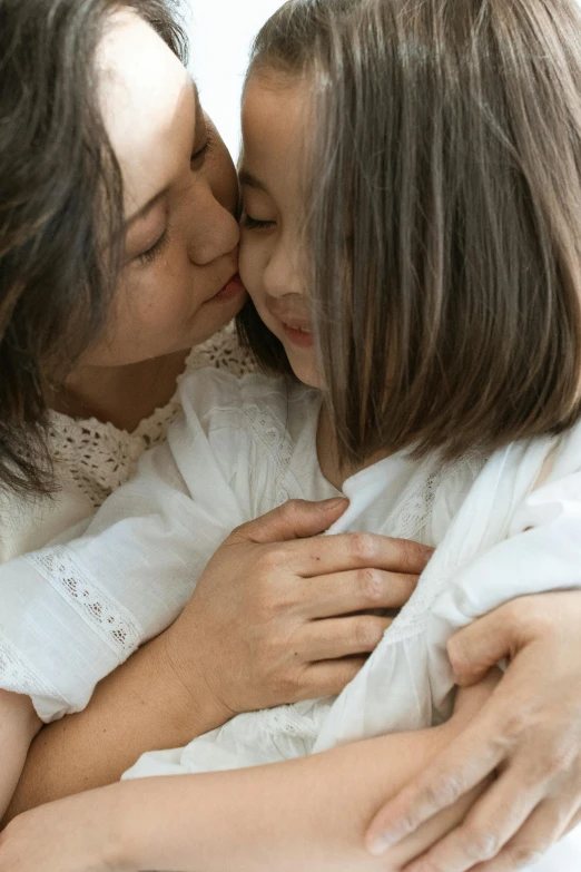 two girls are kissing each other on a bed