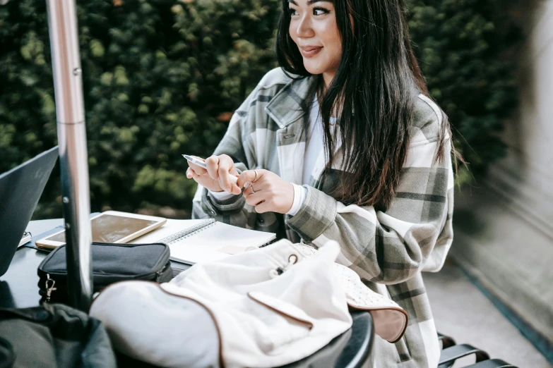 a woman sitting outside by a window with an umbrella