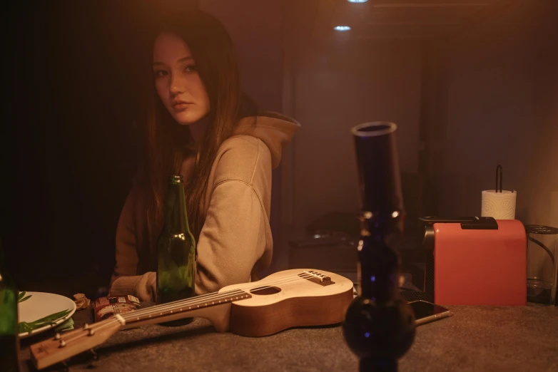 a woman sitting at the counter with a bottle of beer