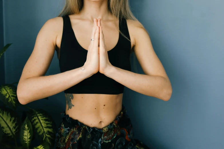 a girl with her hands together in a yoga pose