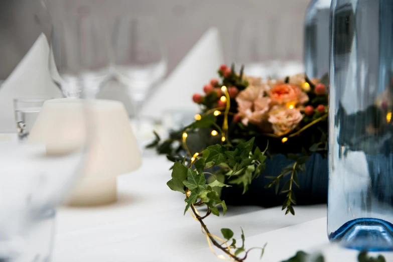 a vase with flowers is set next to an empty wine bottle