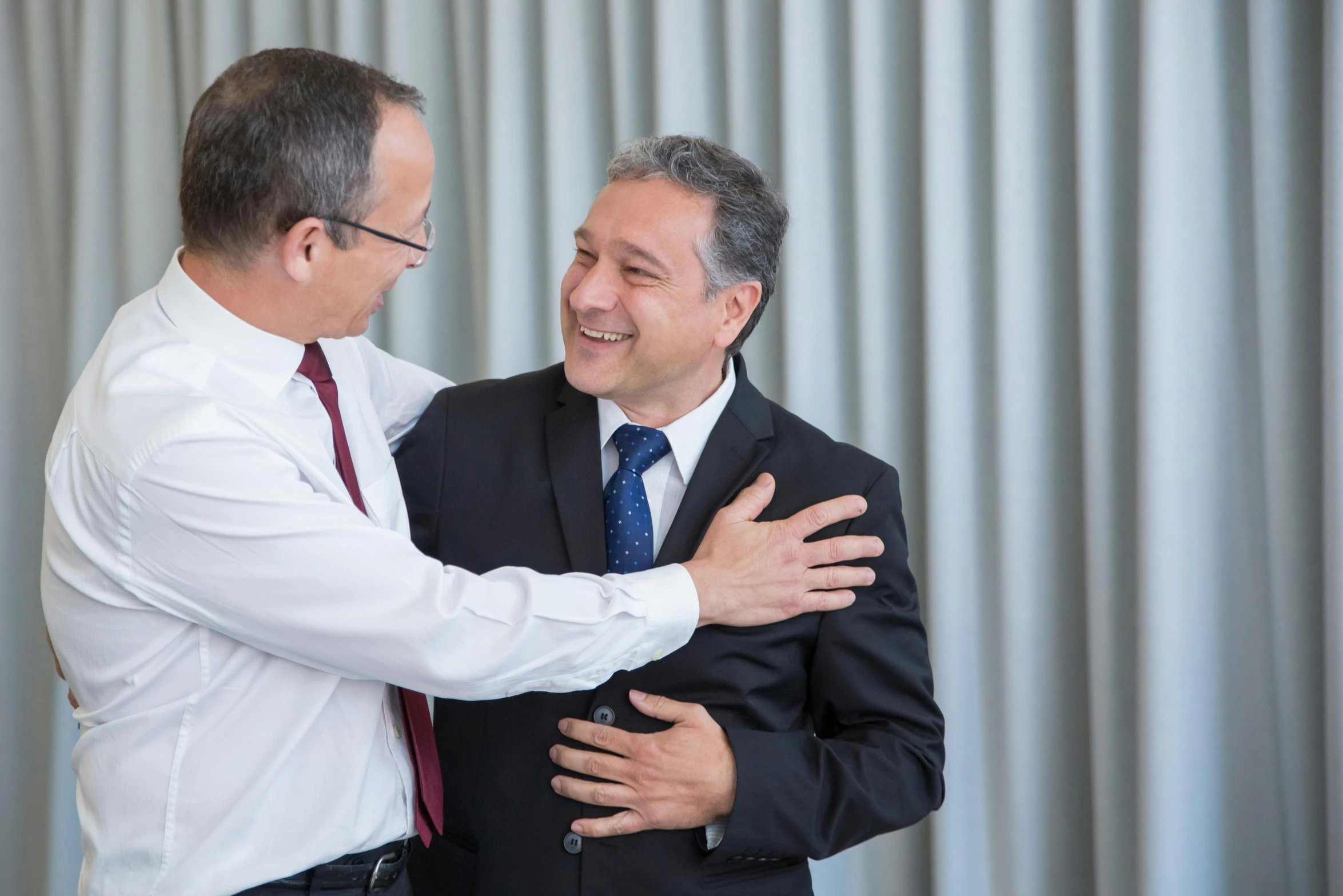 two men dressed in suits emcing each other