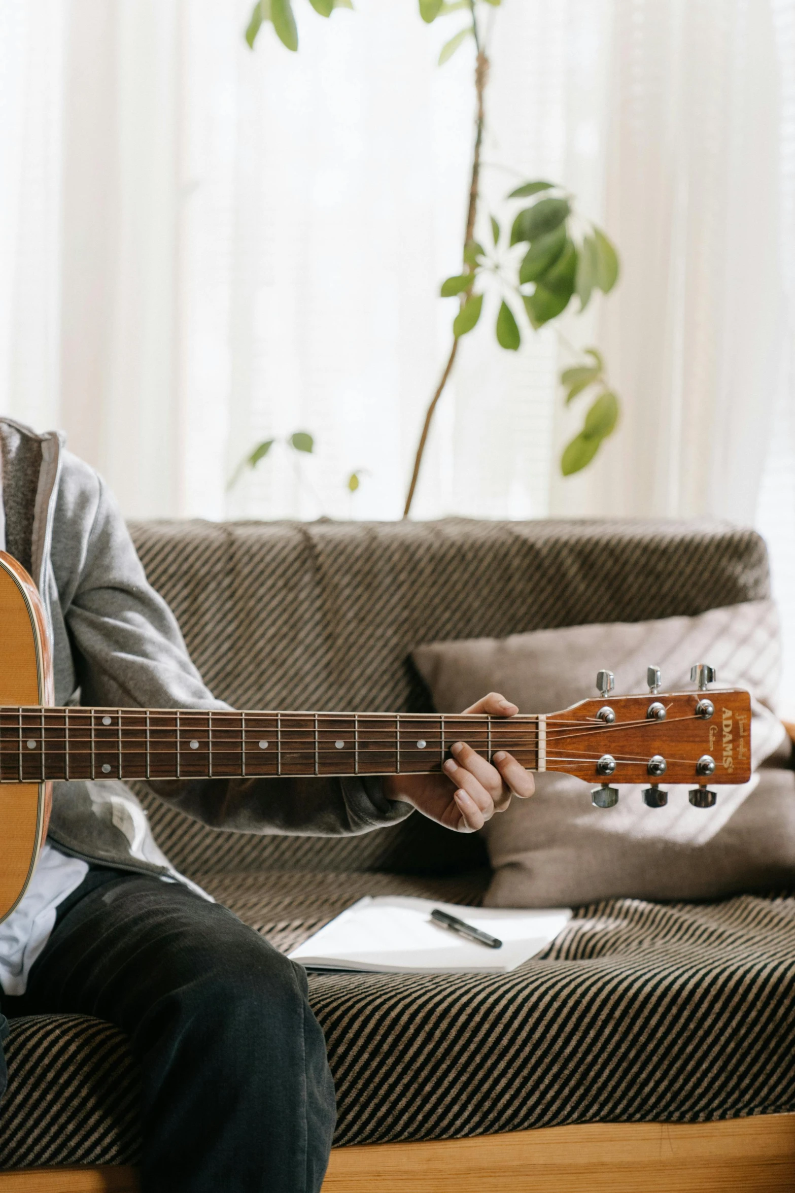 a person sitting on a couch holding a guitar