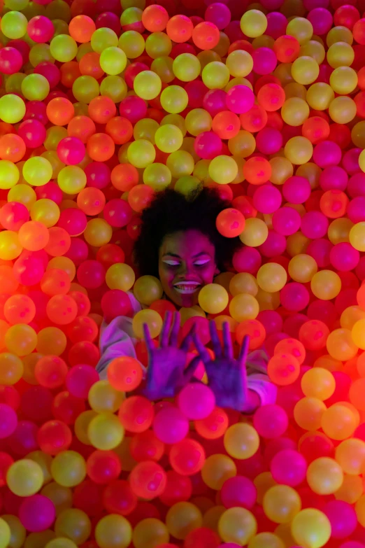 woman is surrounded by colored balls in front of her face