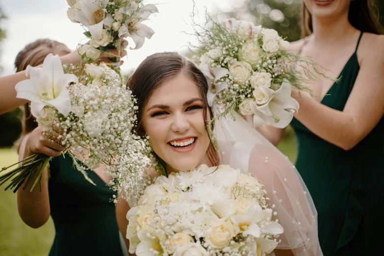 a bride smiles as she poses with her bridal flowers