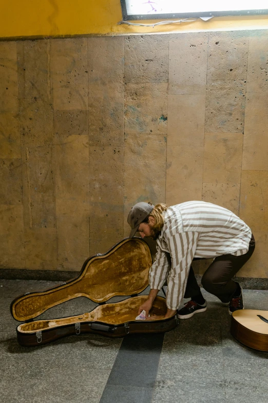 a man is leaning over a guitar case