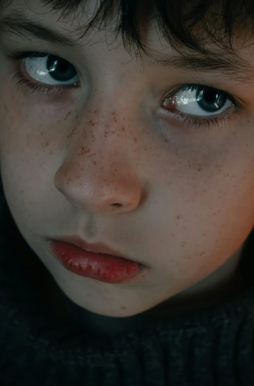 a boy's face that is close up and has freckles on his hair