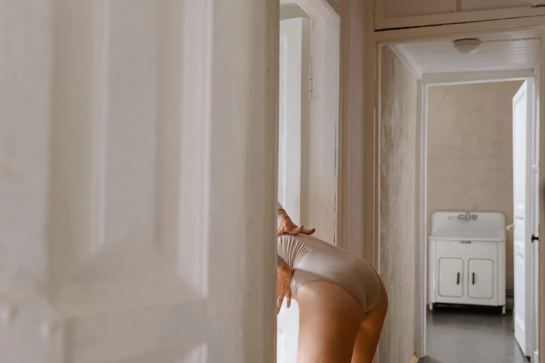 a woman wearing a sheer thong standing in a doorway