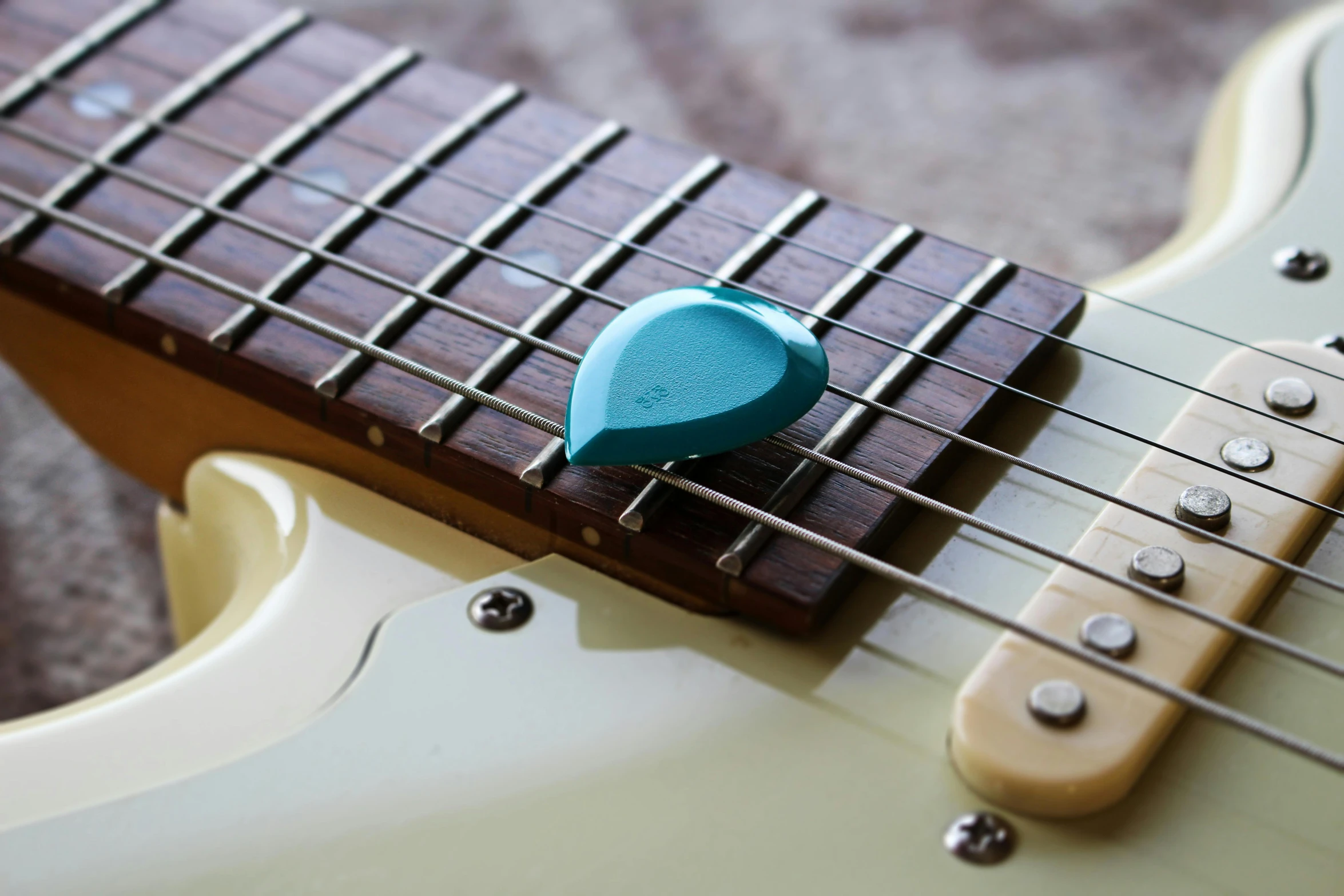 a green guitar picker on the back of an electric guitar