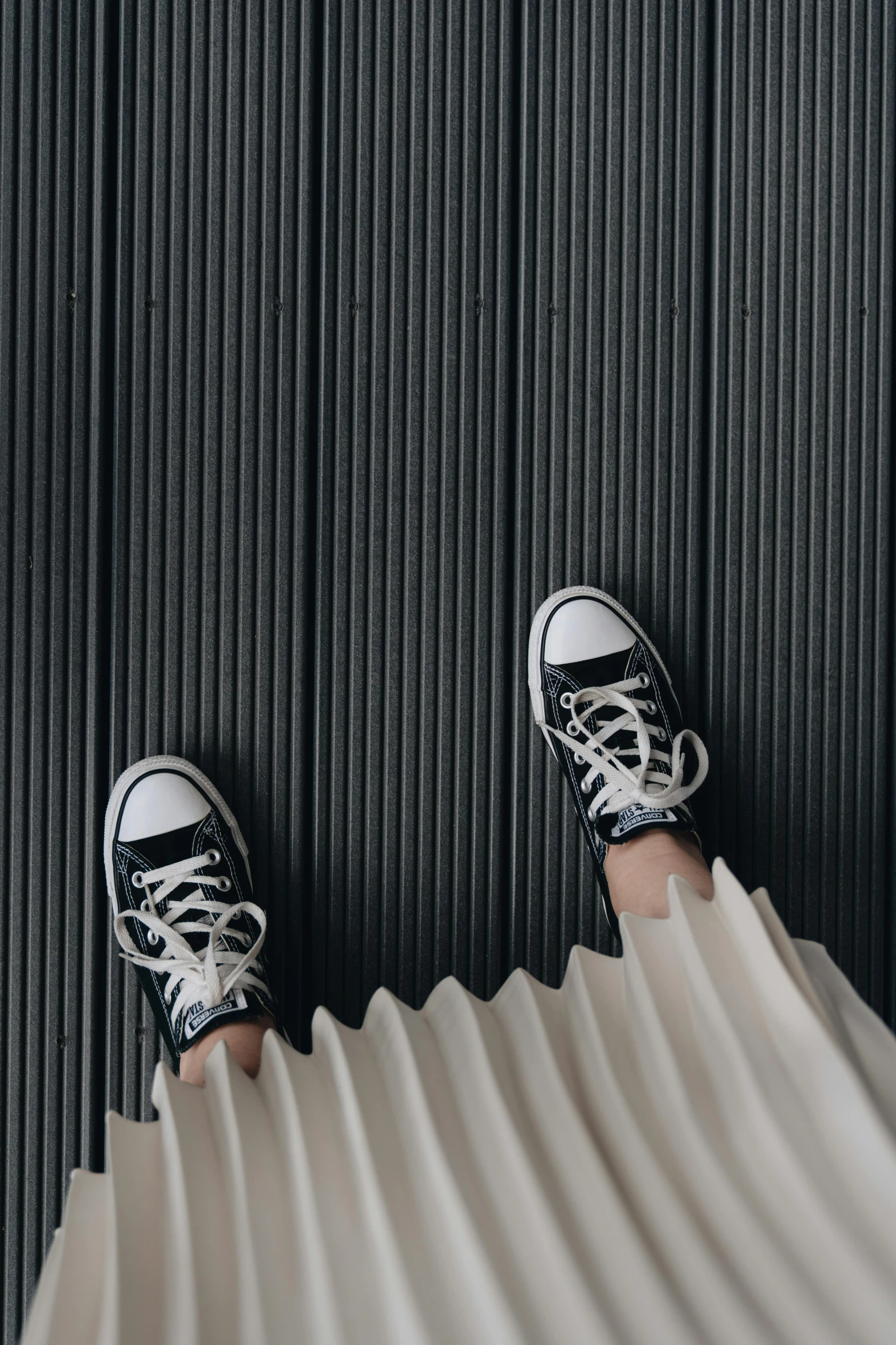 an adult wearing tennis shoes on a wall