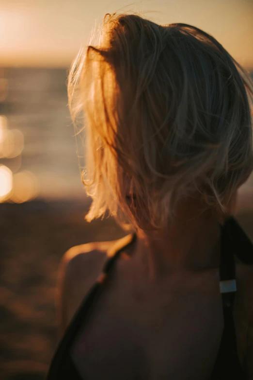 a woman in a bathing suit stands on the beach