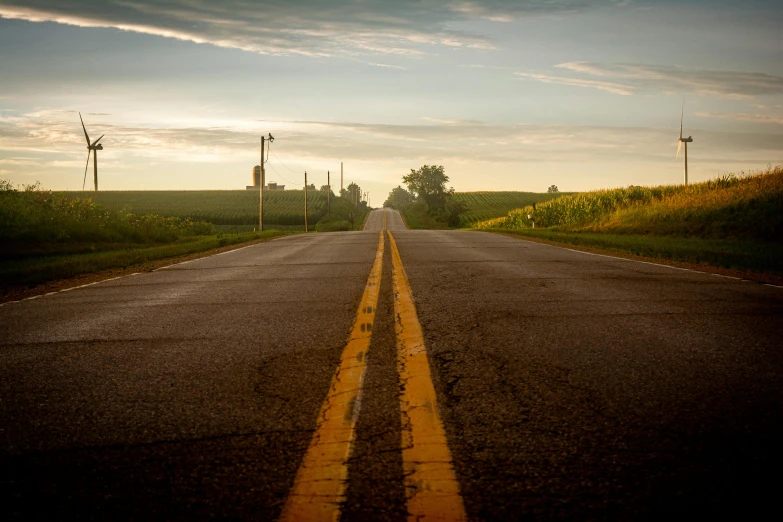 a lonely street with yellow lines on the road