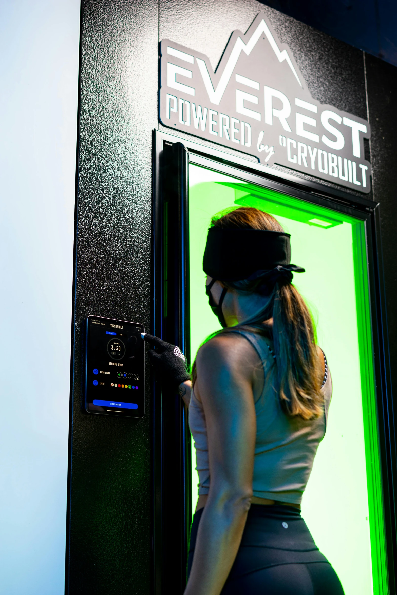 woman in full body underwear standing near door wearing mask