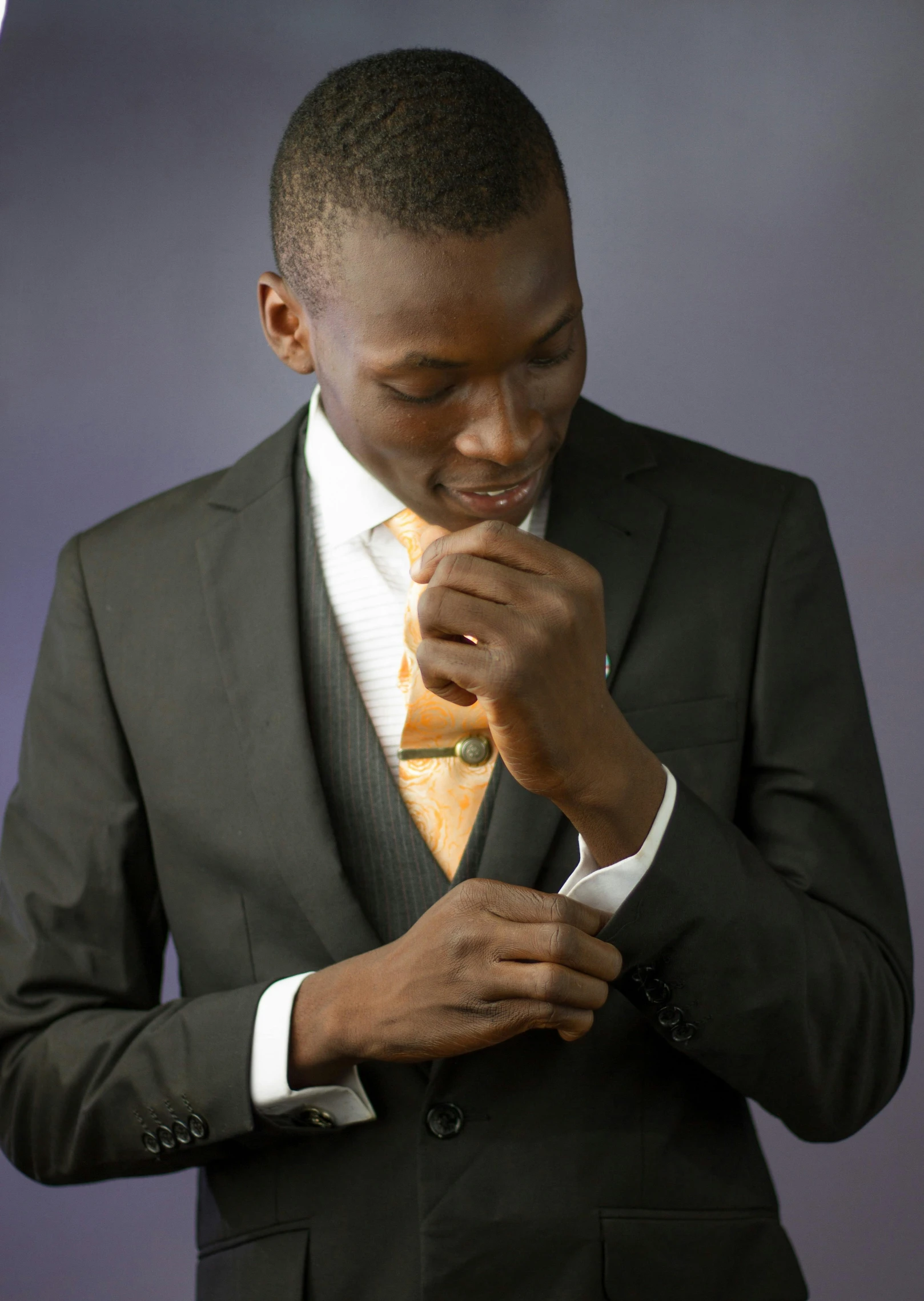 a man in suit and yellow tie getting dressed