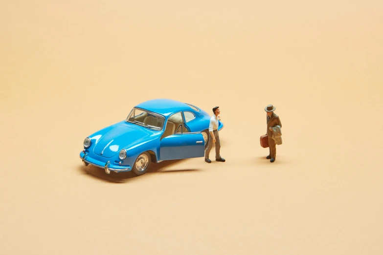 two figurines of a man and a car