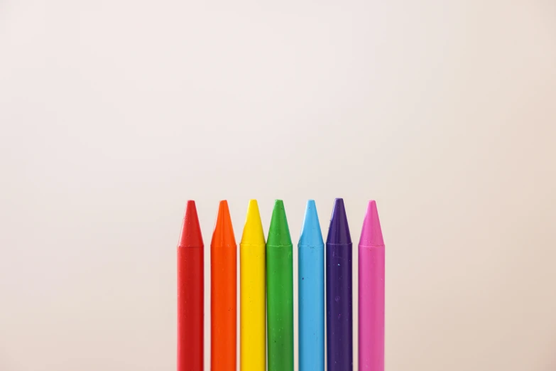 six colored pencils arranged in the shape of a rainbow
