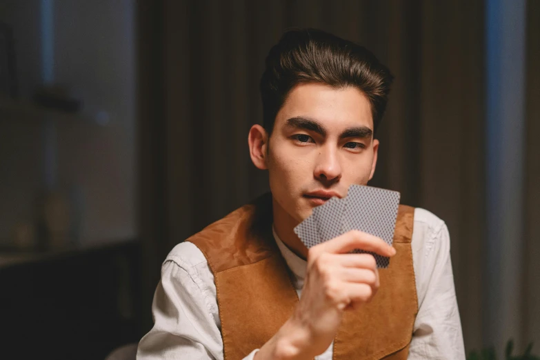 a man holds up a business card to show off it