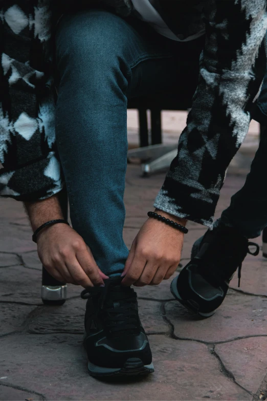 a person tying shoes with his foot on the ground