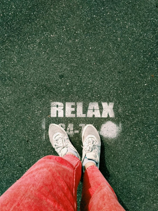 the feet and ankles of a person standing on asphalt