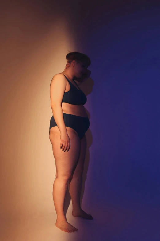 a woman with her leg over her belly and wearing black underwear